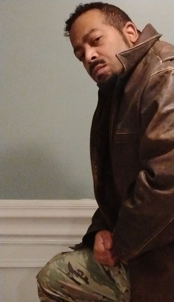 Ripp Donn kneeling in a leather jacket